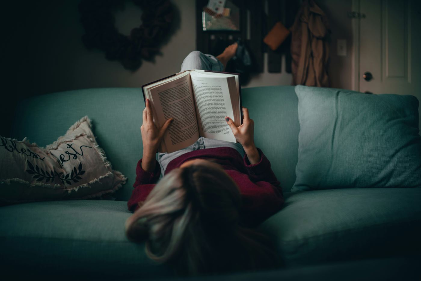 A person reading a book while relaxing on a couch