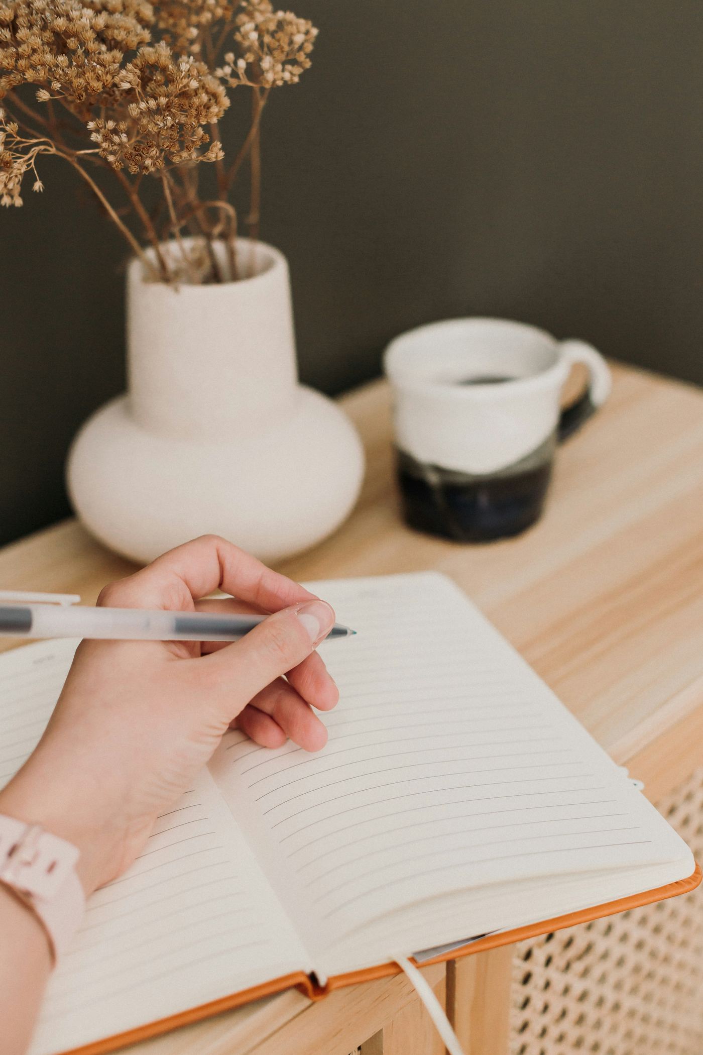 A person writing in a notebook with a pen